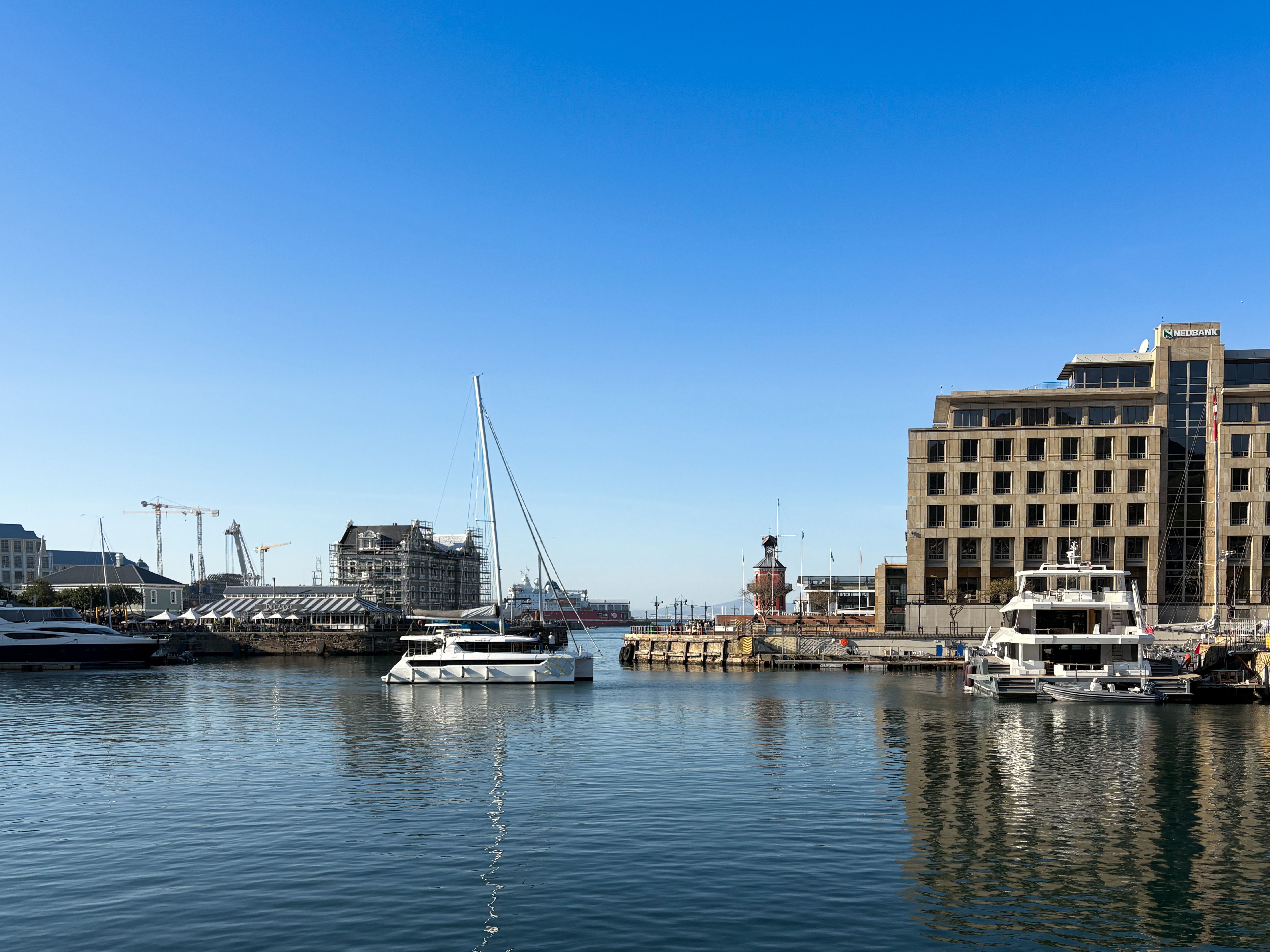 Cape Town marina with boats and modern architecture under clear blue skies