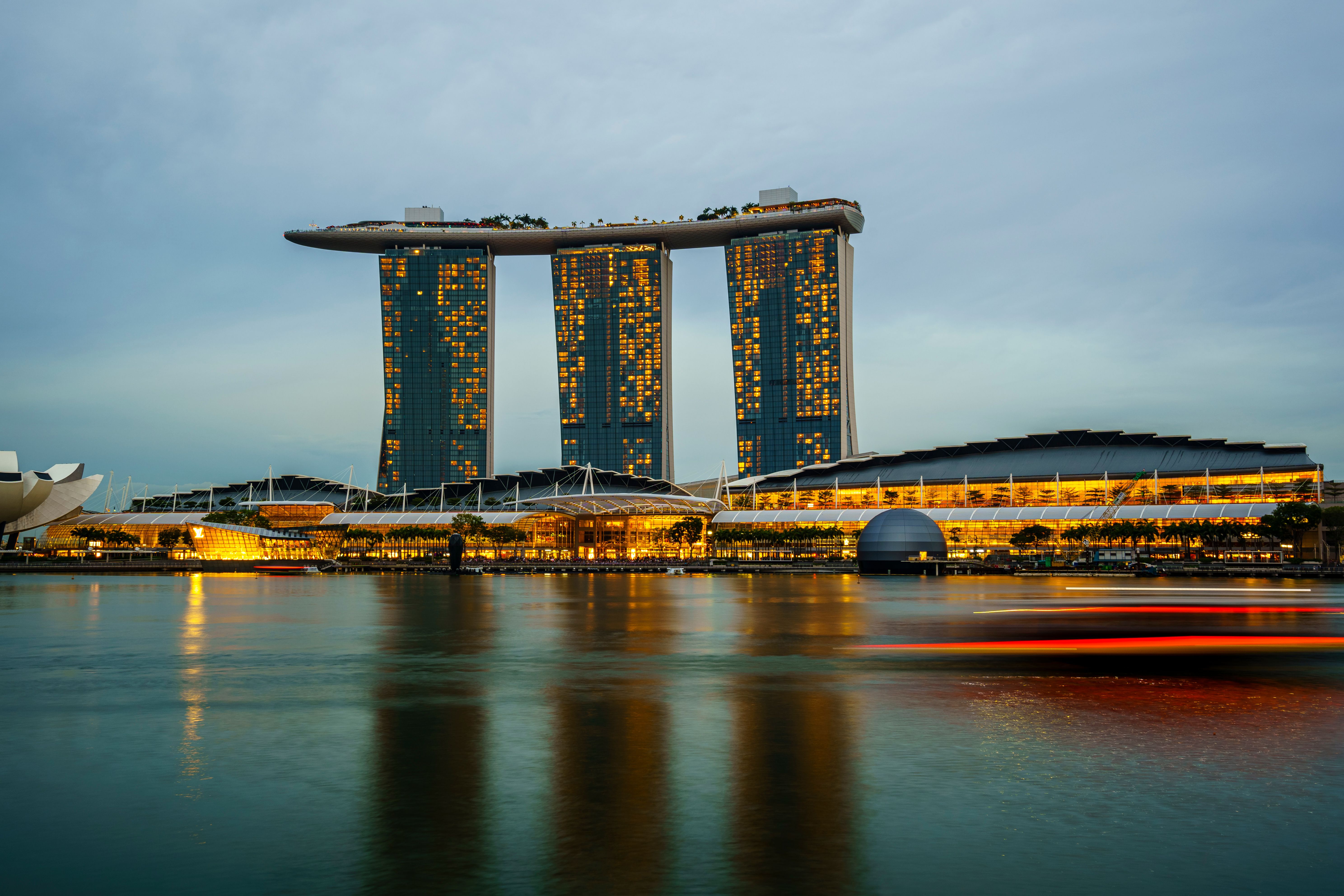 Singapore Marina Bay Sands skyline illuminated at sunset reflecting on the water