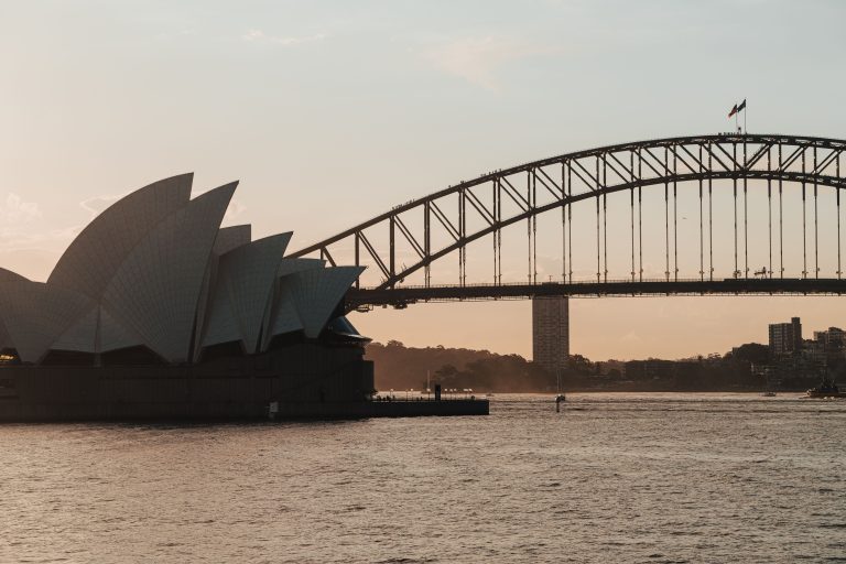 Sydney Opera House and Harbour Bridge at dusk on a tranquil waterfront evening